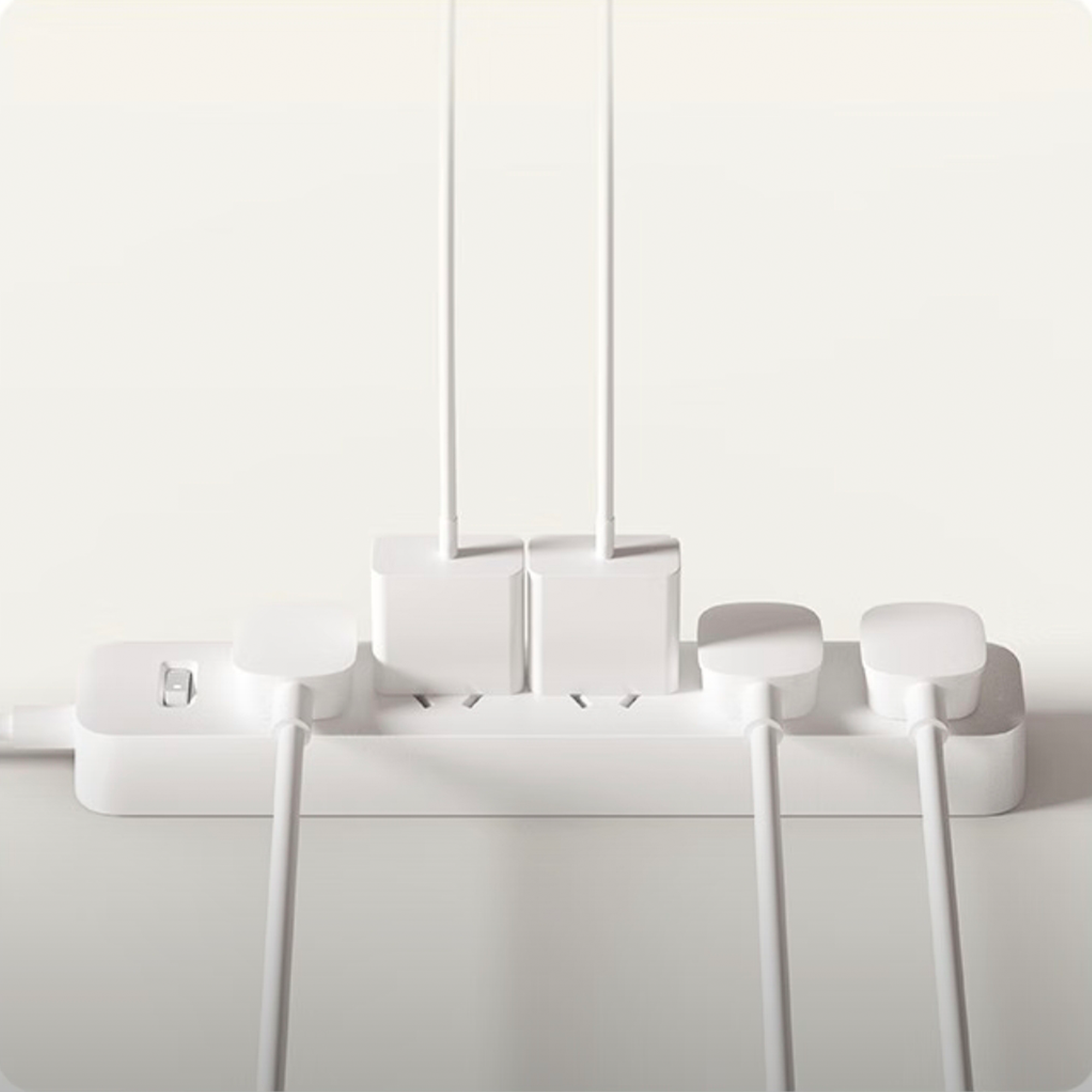White Xiaomi power strip with 6 outlets, a power switch, and four white chargers with cables plugged in.